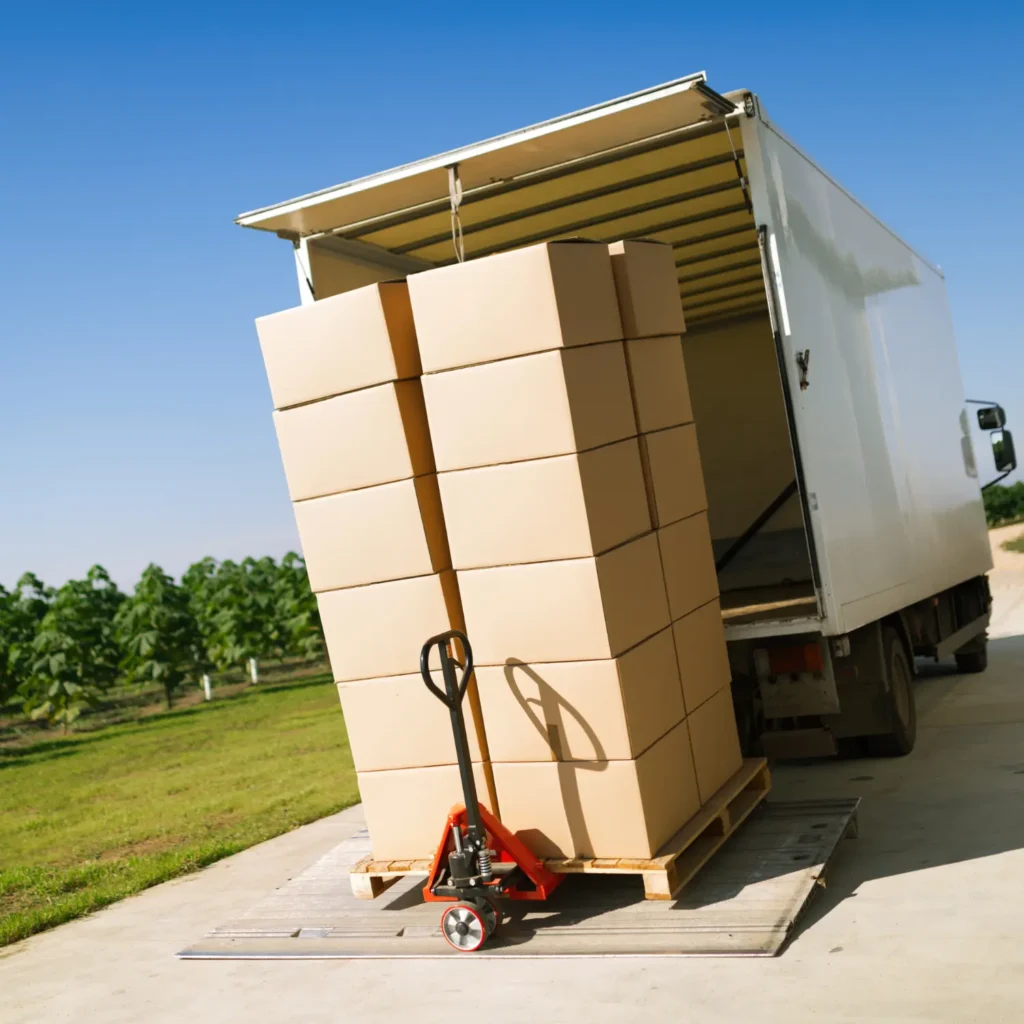Beiladungstransport Hamburg - Hubwagen mit gestapelten Umzugskartons vor Transporter