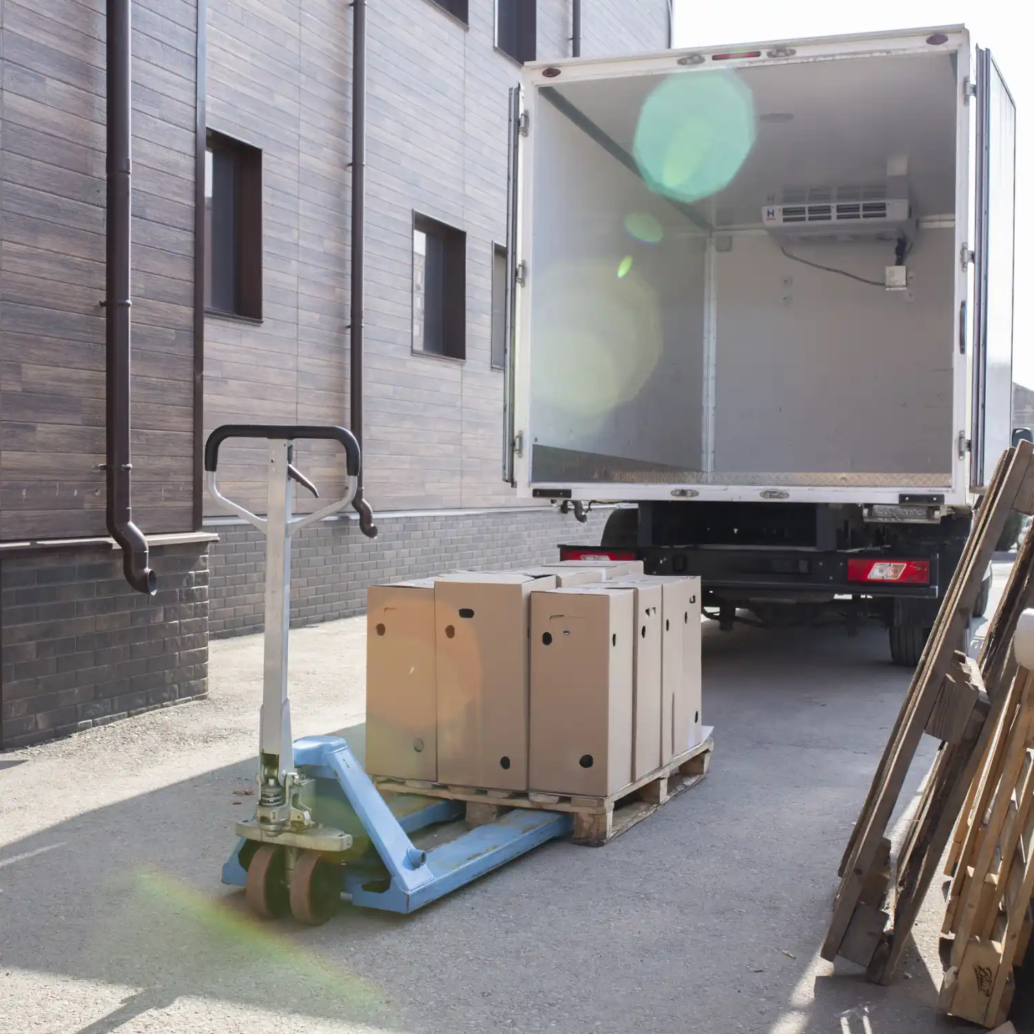 Beiladungstransport Hamburg - Palettenhubwagen mit Frachtkartons bei Warenanlieferung