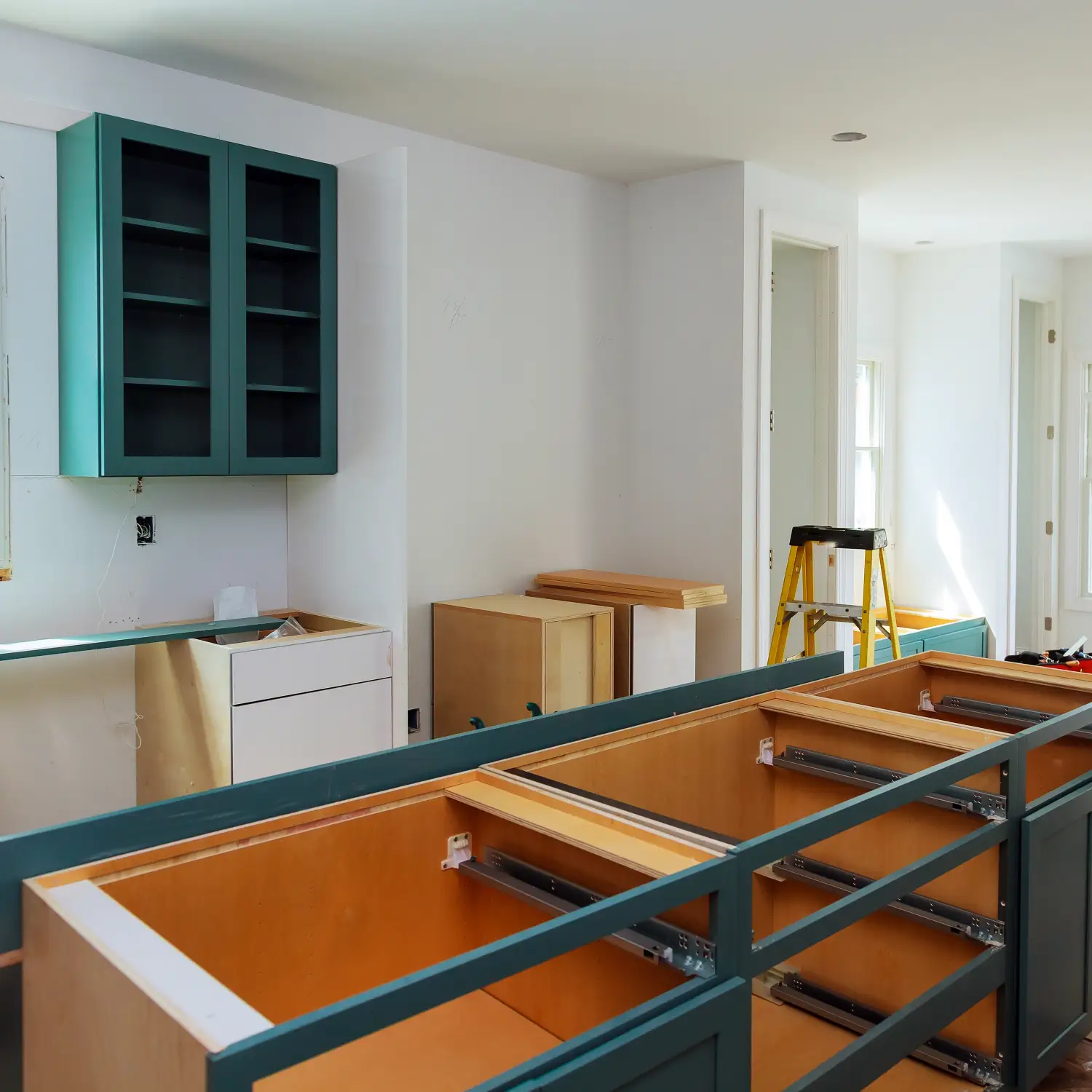 Küchenaufbau in Hamburg: Grüne Hängeschränke und Unterschränke werden montiert