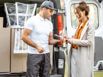 Möbel-Lieferant im Gespräch mit Kundin, die die Lieferung vom Möbeltaxi Hamburg unterschreibt