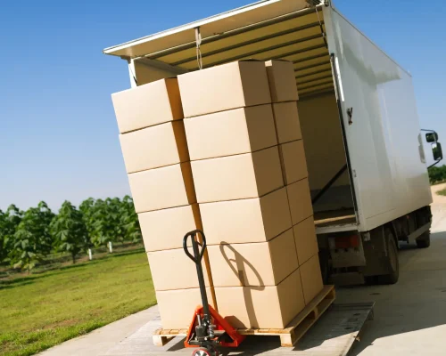 Beiladungstransport Hamburg - Hubwagen mit gestapelten Umzugskartons vor Transporter