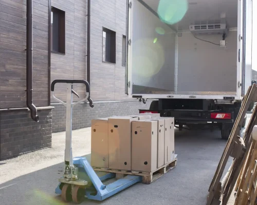 Beiladungstransport Hamburg - Palettenhubwagen mit Frachtkartons bei Warenanlieferung